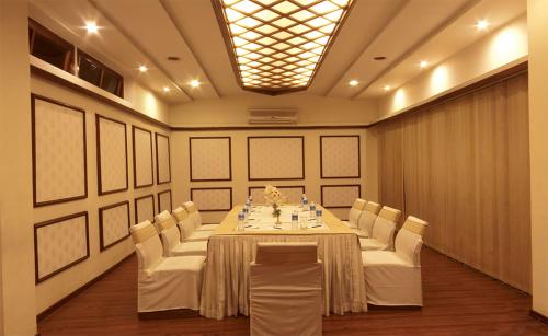 a conference room with a long table and white chairs at Hotel Polo Towers Shillong in Shillong