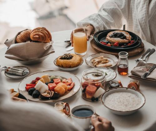 a table topped with plates of food and orange juice at Four Seasons Hotel Kuwait at Burj Alshaya in Kuwait