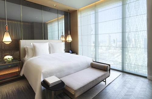 a bedroom with a white bed and a large window at Four Seasons Hotel Kuwait at Burj Alshaya in Kuwait