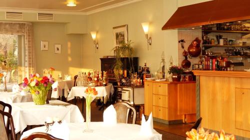 a restaurant with tables with white table cloths on them at Restaurant und Hotel Zum Weissen Ross in Mölln
