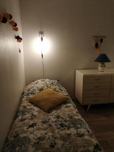 a bedroom with a bed with a lamp and a dresser at Chez Isa et Christophe in Mogeville