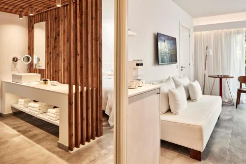 a hotel room with a white couch and a bathroom at So Nice Beach Resort in Ayia Napa
