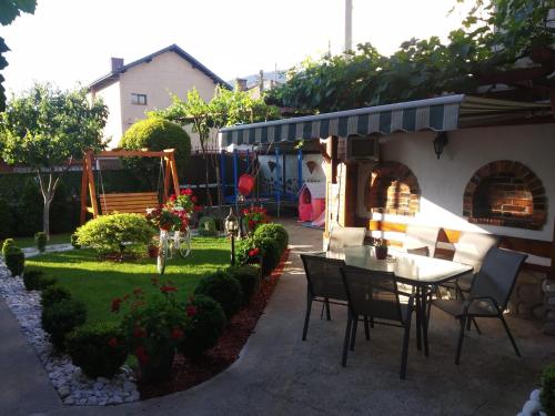 a patio with a table and chairs in a yard at NIKI HOUSE in Bansko