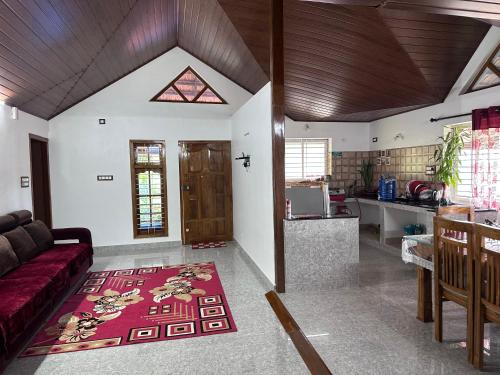 a living room with a couch and a kitchen at Hill View Homestay Madikeri Coorg in Madikeri