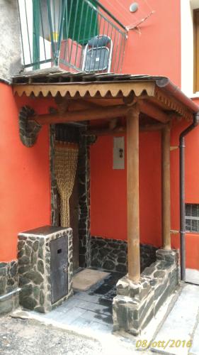a building with a porch with a stone stove at Casa vacanza a 1km dalla funivia in Chiesa in Valmalenco
