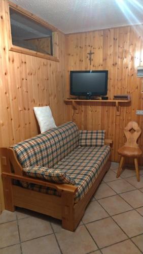 sala de estar con sofá y TV en Casa vacanza a 1km dalla funivia, en Chiesa in Valmalenco