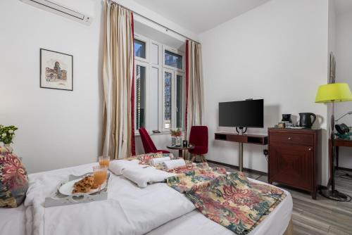 a living room with a table with food on a bed at Continentale - Deluxe Rooms in Rijeka