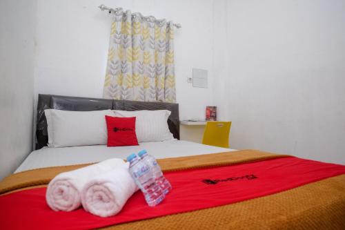 a bedroom with a bed with towels on it at RedDoorz near Politeknik Manado in Paniki