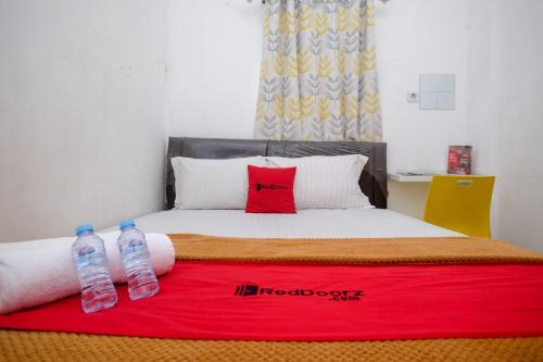 two water bottles sitting on top of a bed at RedDoorz near Politeknik Manado in Paniki