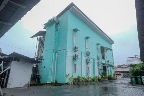 a blue building sitting on top of a street at RedDoorz near Politeknik Manado in Paniki