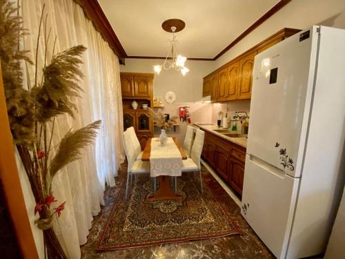 a kitchen with a table and a white refrigerator at Olympus Guest Home 