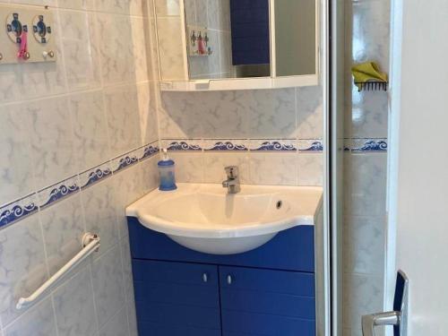 La salle de bains est pourvue d'un lavabo blanc et de placards bleus. dans l'établissement Appartement à 80m² de la Mer avec Terrasse, Jardin et Parking - 4 pers, 35m² - FR-1-540-177, à Notre-Dame-de-Monts