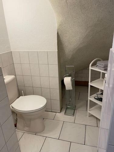 a bathroom with a toilet and a tiled floor at Quartier für zwei in Thale