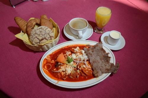 een tafel met een bord eten en een mand brood bij Hotel Casa Antigua in Oaxaca City