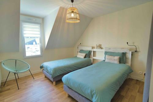 1 Schlafzimmer mit 2 Betten und einem Kronleuchter in der Unterkunft Sea, Surf and Sun in Saint-Pierre-Quiberon