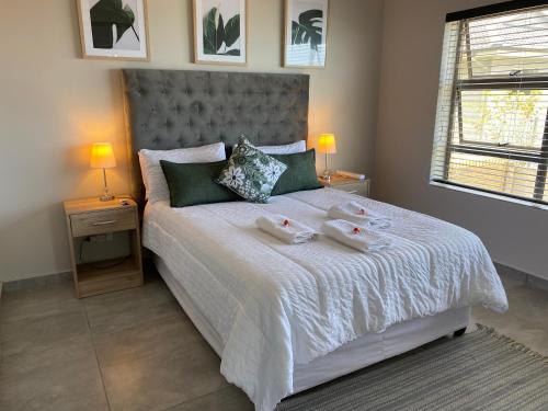 a bedroom with a bed with two towels on it at Tulip On The Bay in Mossel Bay