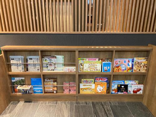 a book shelf filled with lots of books at Hotel Route Inn Osaka Izumifuchu in Izumi
