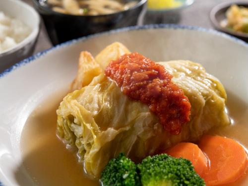 a plate of ravioli and vegetables on a table at HOTEL MYSTAYS Soga in Chiba