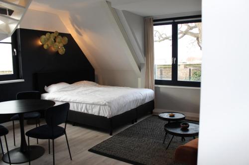 a bedroom with a bed and a table and chairs at Stadsappartementen Harderwijk in Harderwijk