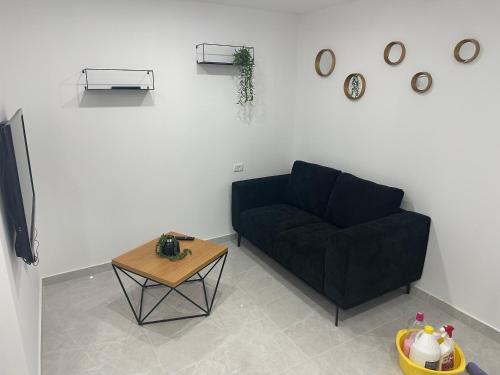 a living room with a black couch and a table at מישל נופש ,צופית תחתית 6003 in Eilat