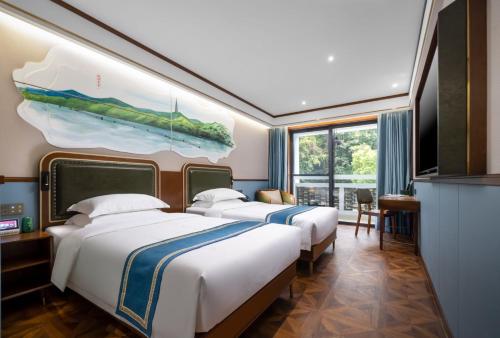 two beds in a hotel room with a painting on the wall at Nostalgia S Hotel Hangzhou West Lake in Hangzhou