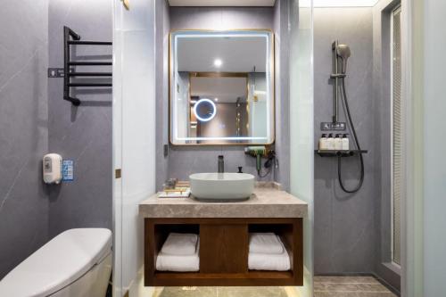 a bathroom with a sink and a mirror at Nostalgia S Hotel Hangzhou West Lake in Hangzhou