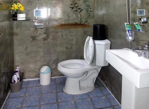 La salle de bains est pourvue de toilettes blanches et d'un lavabo. dans l'établissement Byeolha Guesthouse, à Jeonju