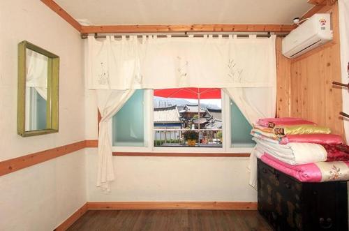 a room with a window and a bed in a room at Byeolha Guesthouse in Jeonju