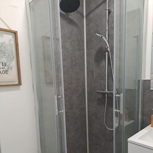 La salle de bains est pourvue d'une douche avec une porte en verre. dans l'établissement Studio de charme, à Saint-Maixent-lʼÉcole