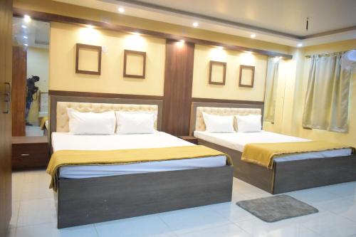1 dormitorio con 2 camas y espejo en Tris Planet Kalyani by Easygorooms!!, en Kalyani