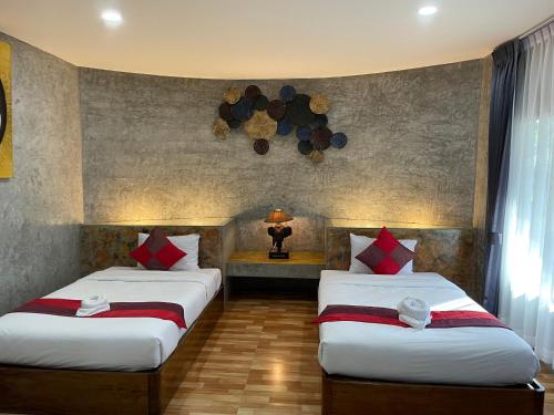two beds in a hotel room with two bedsvisor at Nao Ta Chuang in Thung Song