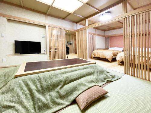 Harumiya Ryokan في فوكوشيما: غرفة نوم بسريرين وتلفزيون بشاشة مسطحة