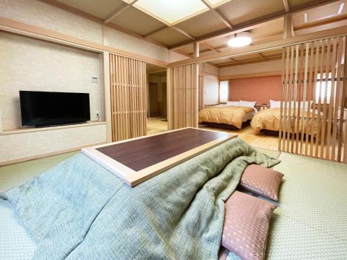 Ένα ή περισσότερα κρεβάτια σε δωμάτιο στο Harumiya Ryokan