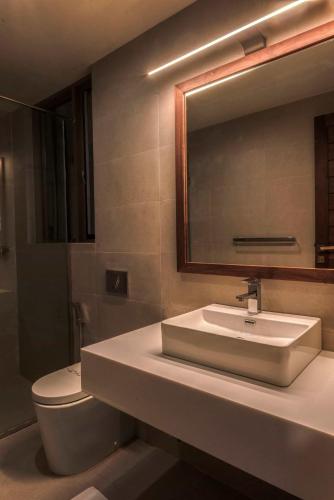 a bathroom with a sink and a toilet and a mirror at Rivora Heights in Kandy