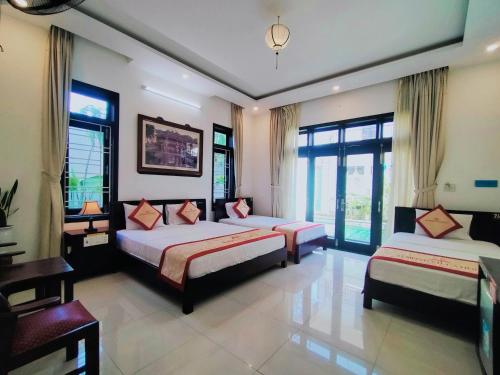 Giường trong phòng chung tại Almond Villa Hoi An