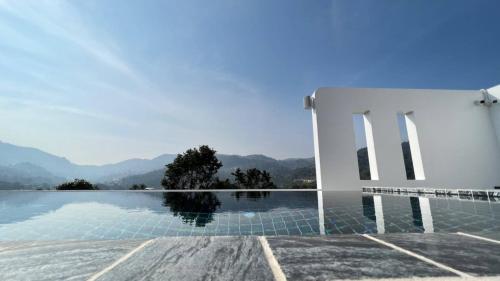 a view of a swimming pool with mountains in the background at 108 Villa @ PongYang in Chiang Mai