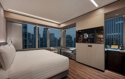 a bedroom with a white bed and a view of a city at Jen Shenzhen Qianhai By Shangri-La in Shenzhen