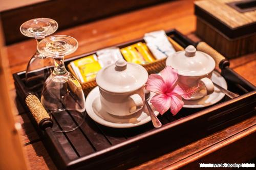 a tray with a tea set and glasses on it at Warisan Villa By Reccoma in Nusa Lembongan