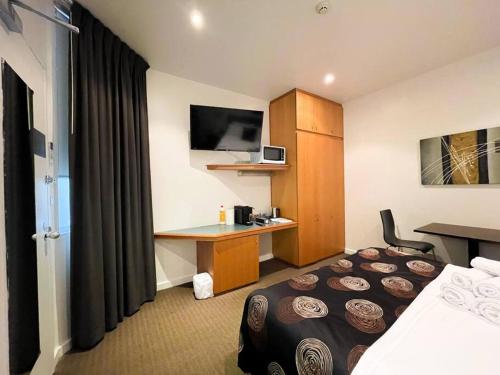 a hotel room with a bed and a desk at city ex hotel ensuite room in city 408 in Adelaide