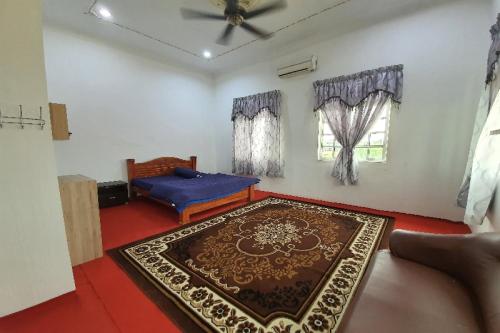 OYO Home 90723 Green Leaf Guest Lodge Kk في كوتا كينابالو: غرفة معيشة مع أريكة وسجادة