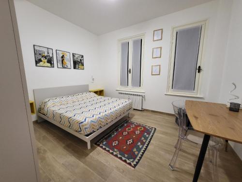 een slaapkamer met een bed, een tafel en een bureau bij La Câza a Zêna in Genua