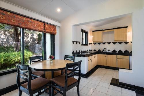 a kitchen and dining room with a table and chairs at Country Inn Nature Resort Bhimtal in Bhīm Tāl