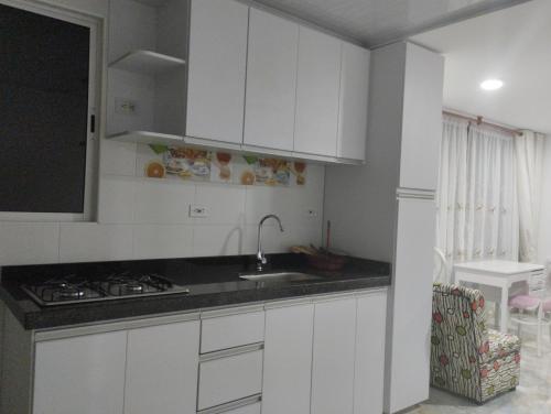 杜伊塔馬的住宿－Refugio Flores de María，白色的厨房设有水槽和炉灶。