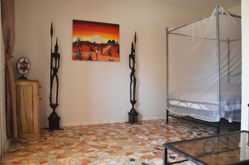 Hotel Takana في Ngaparou: غرفة بسرير ودهان على الحائط