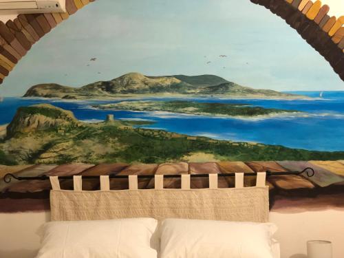 a bedroom with a painting on the wall above a bed at Villa Diana affitta camere in Stintino