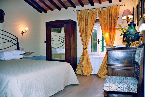 a bedroom with a bed and a window with curtains at Domus Etrusca in San Casciano dei Bagni