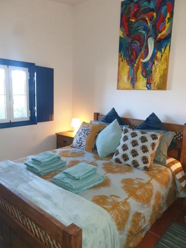 a bedroom with a bed with a painting on the wall at Sondela Self Catering in São Martinho do Porto