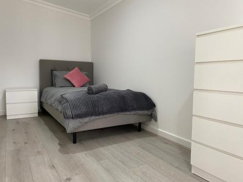 a bedroom with a bed with a pink pillow at Lux Modern 4 Bedroom House Central CBD in Broken Hill