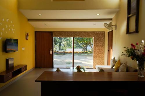 a living room with yellow walls and a couch at Country Inn Nature Resort Bhimtal in Bhīm Tāl