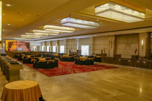 a large room with tables and chairs and a stage at Four Leaf Hotel,Budaun in Budaun